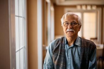 Elderly man in residential care home looking at camera.