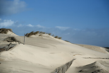 Fototapeta na wymiar Dune de sable blanc avec ciel bleu