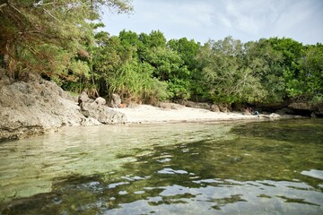 Hidden, small idyllic beach of Siquijor in the Philippines with its own small bay surrounded by trees.