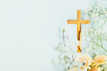 Wooden cross with spring flowers on blue background with copy space. Religion background. Religious church holidays. Christianity Feast, Easter, Palm Sunday, Christening, church wedding. Flat lay - obrazy, fototapety, plakaty