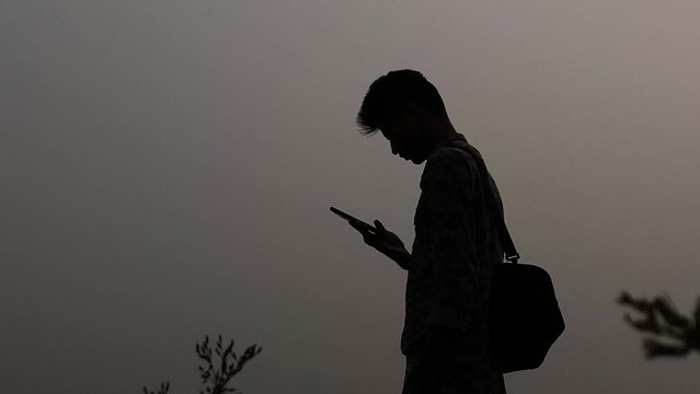 A visual representation of network communication through a mobile phone, depicted by the silhouette of a man, capturing the essence of modern connectivity and technology