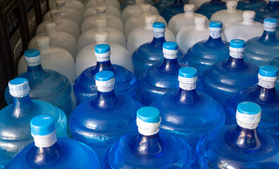 The blue water gallon and white gallon containing drinking water have been sealed with a plastic seal in the drinking water plant to wait for delivery