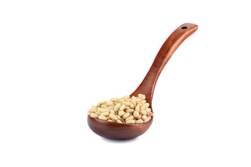 Peeled pine nuts on a wooden spoon on a white background.