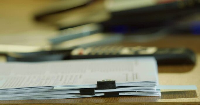 Human dropping a stack of sheets on a desk at the office. A lot of work.