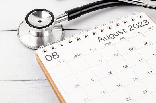 The stethoscope medical and August 2023 desk calendar on wooden background, schedule to check up healthy concepts.