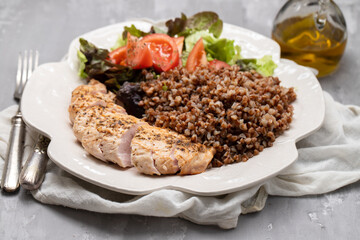 Baked turkey with buckwheat and vegetable fresh salad on plate