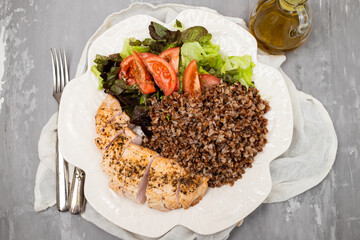 Baked turkey with buckwheat and vegetable fresh salad on plate