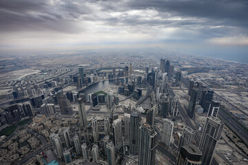 Dubai from above. Aerial view from Burj Khalifa skyscraper tower to city of Dubai during a cloudy day. United Arab Emirates, 2023.