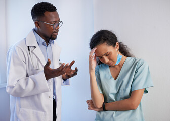 Senior doctor talks to upset junior doctor in scrubs, support mentorship