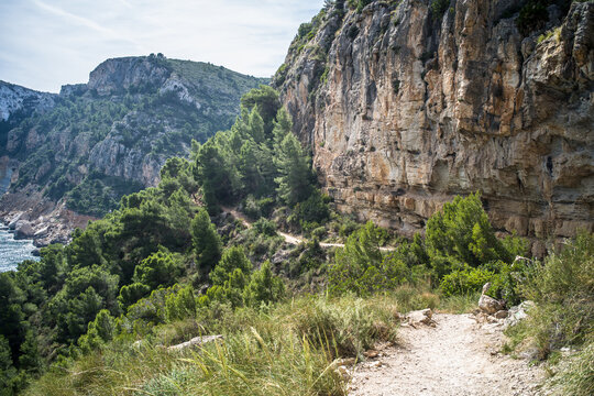 Moraig pebble beach. cliffs, rocks, mountain path and view of the mediterranean sea on a beautiful sunny day
