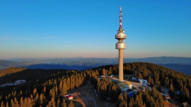 Tower Snezhana on peak of Snezhana covered with spruce forests in Rhodope mountains