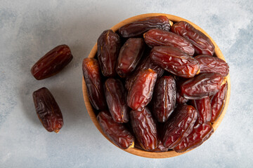 Date fruits in wooden bowl,top view
