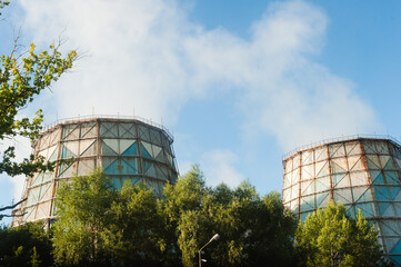 Cooling towers at power plants emit puffs of steam into the atmosphere. Pipes Heat power station against the background of the sky