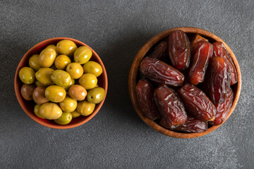 Dates fruit and green olives on a bright background.Traditional iftar table
