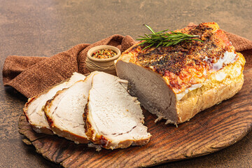 Baked pork loin with spices and herbs on vintage wooden cutting board. Ready to eat meat slices