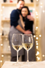 Silhouette of a couple in love in the background and two glasses of champagne in the foreground 