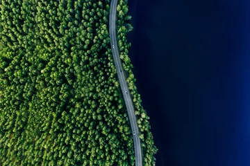 Foto op Plexiglas Aerial view of road in green woods and blue lakes water in Finland © nblxer