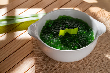Pearl Porridge or pearl sago. Popular Indonesian desserts are commonly encountered during the month of Ramadhan. Served in a ceramic bowl with pandan leaves.