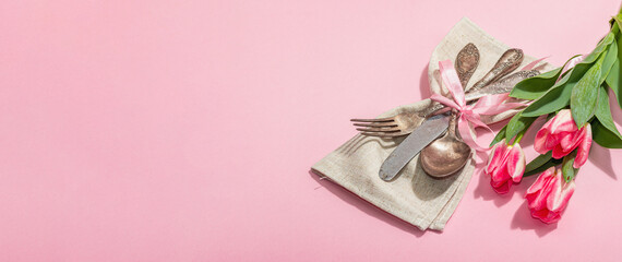 Romantic table setting with pink tulips. Vintage cutlery, fresh flowers, napkin. Festive concept