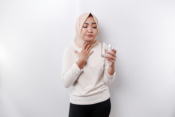 An Asian Muslim woman feels so thirsty because of the hot weather during the summer season while...