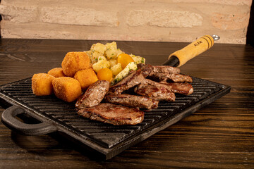 Porção de carne com queijo empanado e mandioca