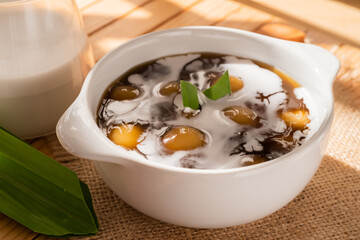Bubur Candil or Indonesian rice flour porridge with sweet potato sticky rice balls, served with palm sugar sauce in a white bowl