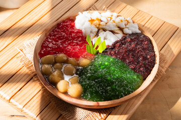 Pearl porridge or pearl sago. Popular Indonesian desserts served on wooden plates with various flavours