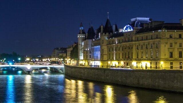 Cite island aerial view with Conciergerie Castle and Pont au Change, over the Seine river timelapse hyperlapse. Night illumination reflecter in water. France, Paris