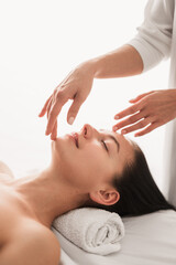 Obraz na płótnie Canvas Crop therapist massaging clients face during session