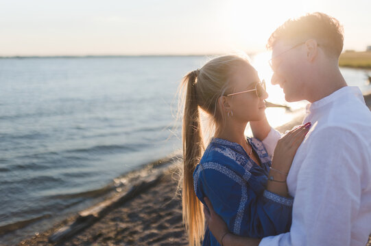 Young cupple cuddling during sunset at sea.