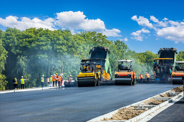 Fototapeta na wymiar Construction site is laying new asphalt pavement, road construction workers and road construction machinery scene. Highway construction site scene.
