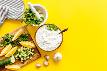 Bowl of dip sauce sour cream with herbs and garlic. Homemade dairy product background