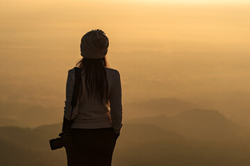 Silhouette of photographer taking picture of landscape during sunset