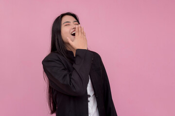 A young woman mockingly laughs at someone, deriding a person. Isolated on a light pink background.