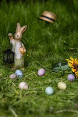 Easter rabbit on a green grass with painted eggs around it