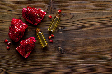 Bottle of pomegranate seed oil with fresh fruits. Natural cosmetic and treatment product