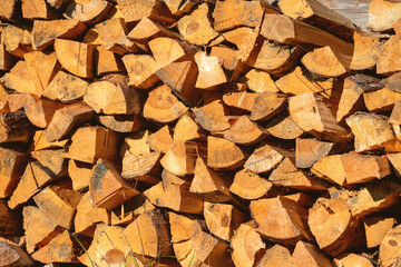 Firewood pile stacked chopped wood trunks for winter heating fireplace