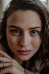 Portrait of young pensive woman, in her apartment.