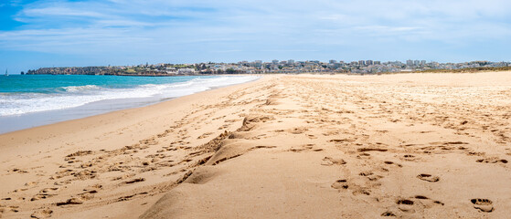 Panoramic view of the calm waters of Meia Praia beach during low tide, showcasing the iconic...