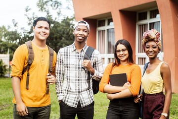 Multi ethnic group of four students smilling looking at camera.