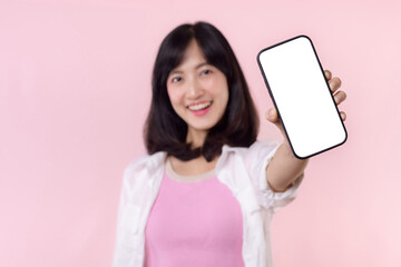 happy smiling young asian woman recommending showing new application or mobile advertisement, mockup smartphone template banner isolated on pink background. Collage blank screen digital mobile device.