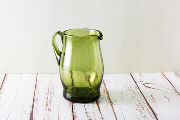 Empty bottle green glass jug.Transparent  jug of classic style in the interior. Copy space for text.