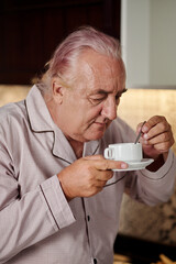 Portrait of senior man enjoying smell of fresh coffee