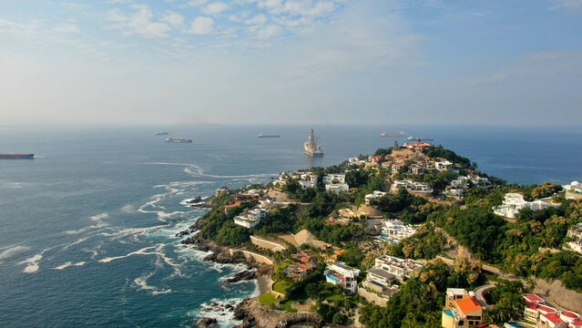 Aerial view of Peninsula de Santiago in city Manzanillo, Mexico. Beautiful bitch and luxury hotels and offshore   drilling ship platform and tanker ships  at anchor in the bay
