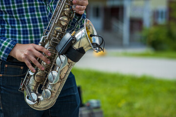 street saxophonist plays the saxophone outdoors