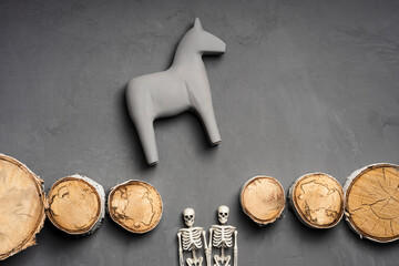 a toy horse stands on the edge of a destroyed bridge, there are two skeletons below the bridge