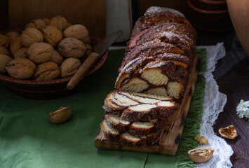 Traditional Easter bread with chocolate and nut filling on a wooden background. - 585867759