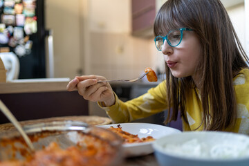 Small girl eating Homemade potato gnocchi with tomato sauce