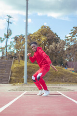 Obraz premium Joven afro bailando al estilo urbano en un parque, con hermosa vegetacion y cielo de fondo