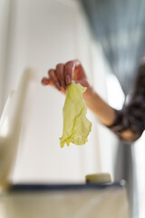 Woman throwing cabbage leaf into composter bin. Female recycling organic food waste into ecological...